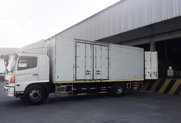 Fototapeta premium Cargo Container Truck Parked Loading at Dock Warehouse. Cargo Shipment. Industry Freight Truck Transportation. Shipping Warehouse Logistics. 