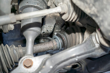 Broken CV Axle Joint on 4WD SUV Close-up with dirty CV Boot Leaking. 
