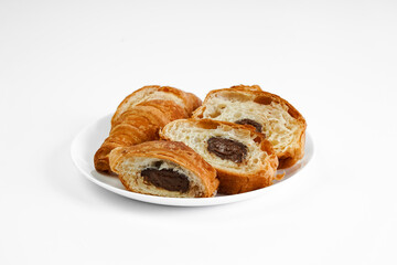 croissant with chocolate sliced ​​on a white plate. homemade baking. french breakfast