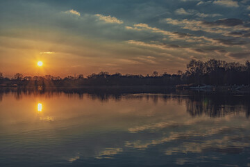 Fototapeta na wymiar Fotografieren des Sonnenuntergangs auf dem See im Frühjahr. Baggersee Ingolstadt