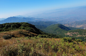 Naklejka premium Natural landscape of green mountain range with misty summit hill