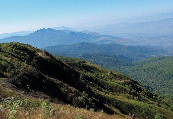 Naklejka premium Natural landscape of green mountain range with misty summit hill