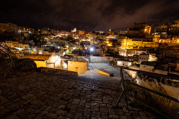 Amazing lighted buildings in ancient Sassi district by night in Matera, well-known for their ancient cave dwellings. Basilicata. Italy