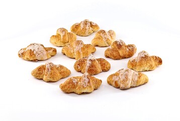 Side view of a group of glazed mini croissant on white background.