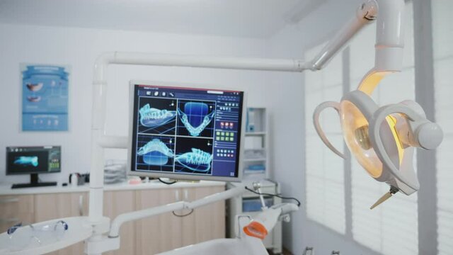 Closeup of stomatology teeth xray images on monitor revealing teethcare treatment. Modern orthodontist hospital office room equipped with professional light lamp and dentistry tools
