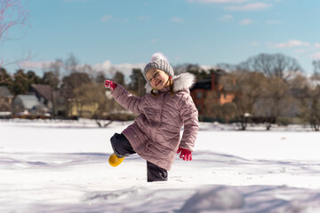 Fototapeta na wymiar child girl fell into a snowdrift knee-deep. large snow level