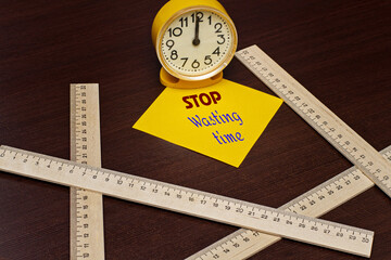 STOP WASTING TIME reminder on yellow sticker next to alarm clock