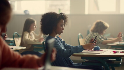 Schoolgirl doing test inline on digital tablet. Girl using tablet computer 