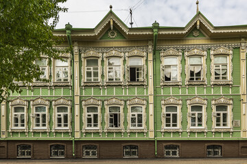 Fototapeta premium Windows with carved platbands of an old wooden house