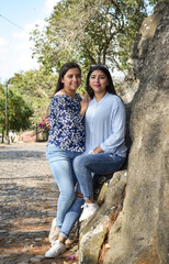 Retrato de dos Mujeres amigas Guatemaltecas, en un parque rodeado de naturaleza al aire libre.