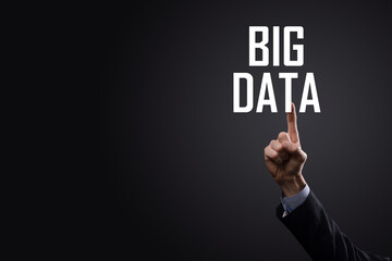 Businessman in a suit on a dark background holds the inscription BIG DATA. Storage Network Online Server Concept.Social network or business analytics representation