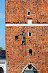 14th century gothic entrance Opatowska Gate, sculpture of a bargeman going down the line Sandomierz, Poland