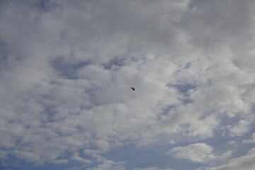 The blue dark clouded sky with a lot of clouds with a helicopter. Background or backdrop