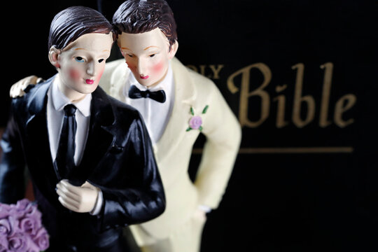 Bible and wedding couple figurine of two men bible. Symbolic image for same-sex marriage.  France.