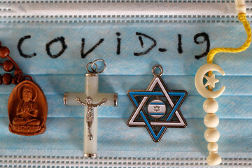 Coronavirus (COVID-19)  epidemic.  Interreligious symbols on a medical mask. Buddhism, Christianity, Islam, and Judaism. â€¨