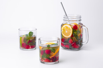 Cocktail isolated on white background. Lemon and lime, mint and raspberries cocktail.