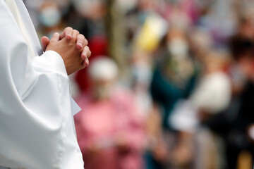 Catholic church during covid-19 epidemic.  Celebration of the mass. Priest praying.  Close-up on hands.  Sanctuary of La Benite Fontaine.