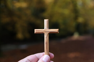 Christian wooden cross in hand. Faith and spirituality.