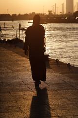  Silhouette of muslim woman with abaya at sunset.  Dubai. United Arab Emirates