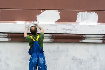 Restoration process of an old house. The plasterer prepares the facade of the building for...