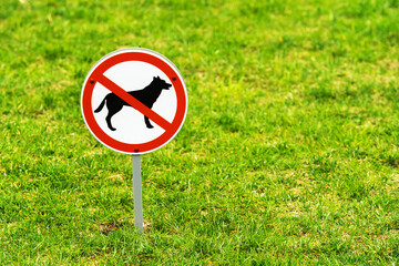 Walking dogs is prohibited. There is an information sign for pet owners on the lawn. Copy space