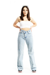 Fototapeta premium Beautiful young stylish woman in hard sunny summer light posing with hand on hips. Full body length isolated on white background