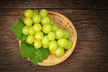 Japanese Shine Muscat Grape in basket  on wooden Background, Sweet Green grape on wooden background.
