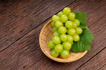 Japanese Shine Muscat Grape in basket  on wooden Background, Sweet Green grape on wooden background.