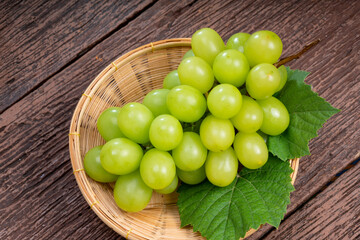 Japanese Shine Muscat Grape in basket  on wooden Background, Sweet Green grape on wooden background.