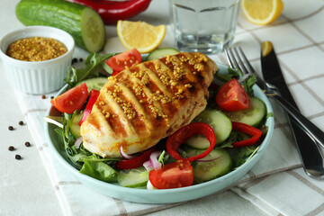 Salad with grilled chicken on white textured table