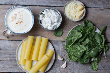 Ingredients for making cannelloni with spinach and ricotta in béchamel sauce, top view, horizontal