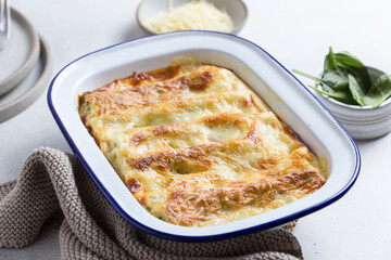 cannelloni with spinach and ricotta in enamel baked with béchamel sauce and cheese, selective focus