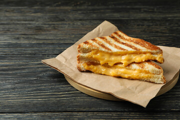 Board with grilled sandwiches on wooden table