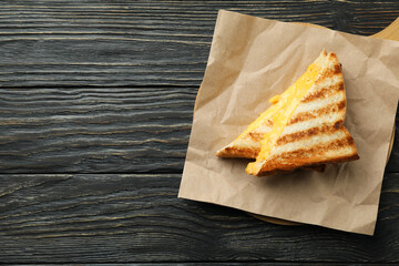 Board with grilled sandwiches on wooden table