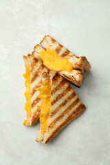 Grilled sandwiches on white textured background, top view