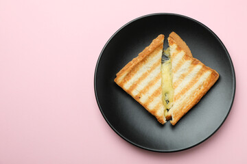 Plate with tasty grilled sandwich on pink background
