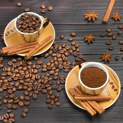 Ground coffee and roasted coffee beans in cups. Cinnamon sticks on saucer. Coffee beans and star anise on table.