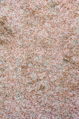 The texture of the rough surface of a red granite slab. As a natural background.