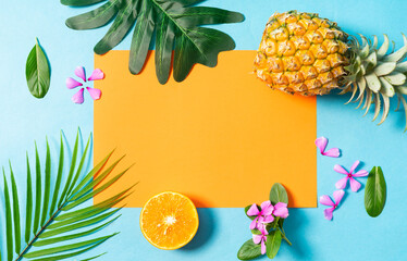 Summer background with orange, pineapple, flower and leaf on blue background