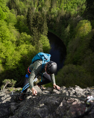 A man climbing a mountain. Alpine ferrata ascent to a peak or summit. Summer adventure mountain...