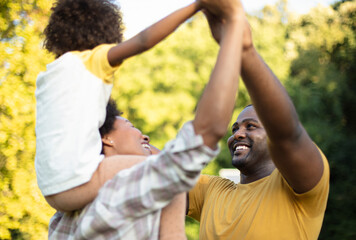 African American family having fun outdoors. Focus is on background.  Family having fun together.