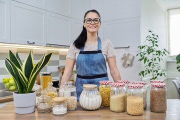 Portrait of smiling woman housewife in an apron in kitchen