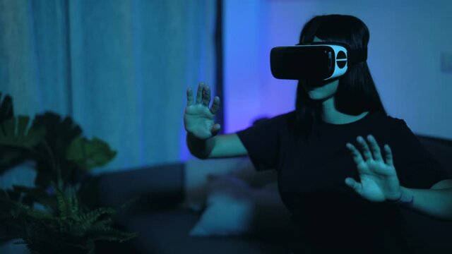 Young woman playing with virtual reality glasses at home - Happy teenager having fun with innovated vr googles technology - Tech entertainment and youth lifestyle concept