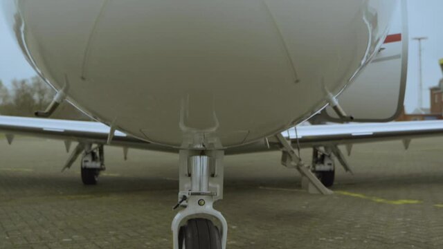 Close up dolly shot of luxury cessna citation jet parking at airport during cloudy day.
