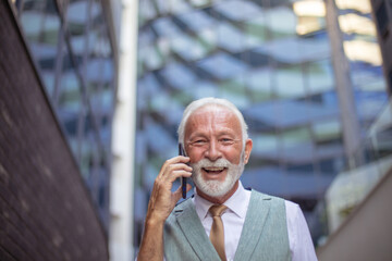 Senior business man talking on smart phone. Looking at camera.