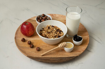 Healthy breakfast, honey, prunes,  muesli, nuts, milk.