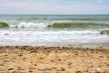 Vagues arrivant sur une plage de sable avec l'horizon en fond