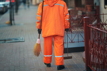 Municipal worker sweep city street, janitor with broomstick and scoop for garbage, evening work....