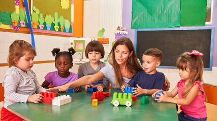 Childminder and children playing with building blocks