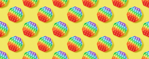 Seamless pattern of popular silicone colorful anti stress pop it toy for child on yellow background. Push Pop Bubble. Banner.